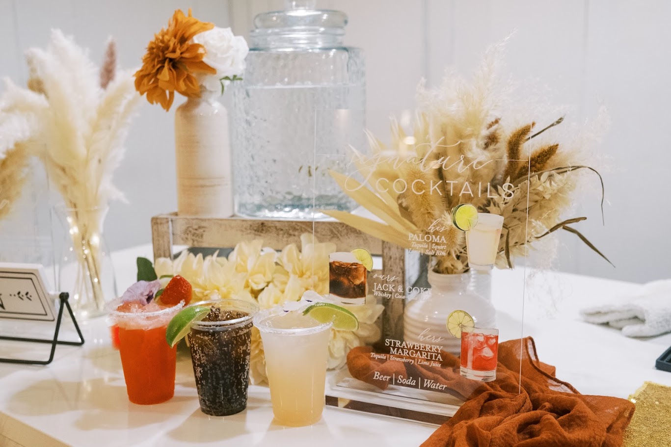 signature cocktails sitting next to sign at wedding