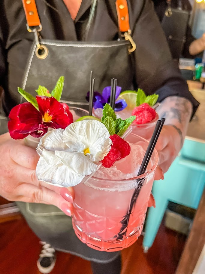 colorful cocktails with fruit and flower garnishes