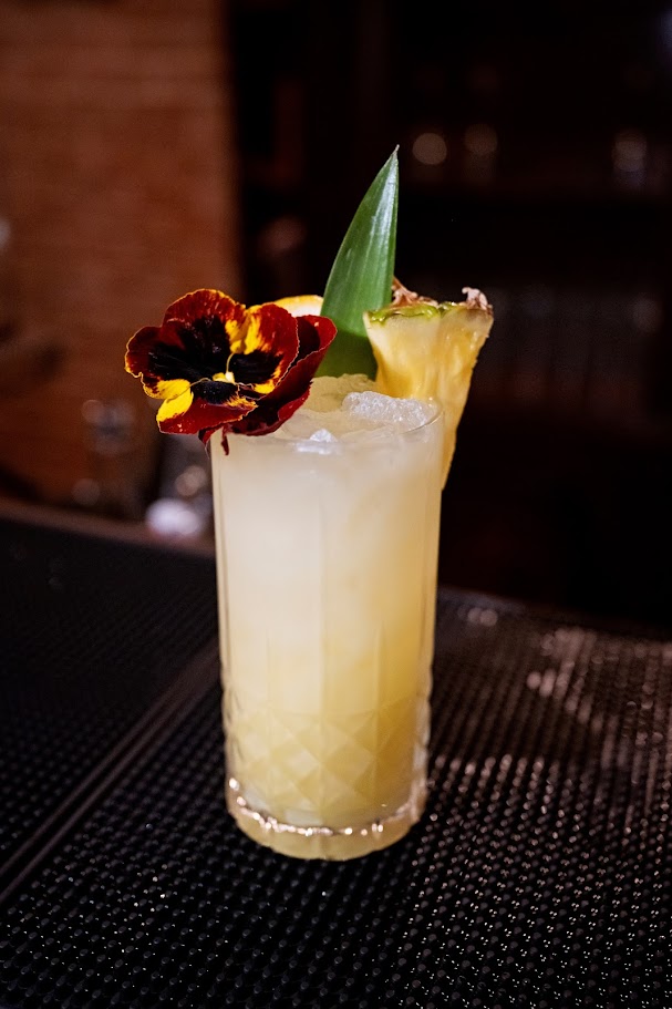 pineapple cocktail with pansy garnish