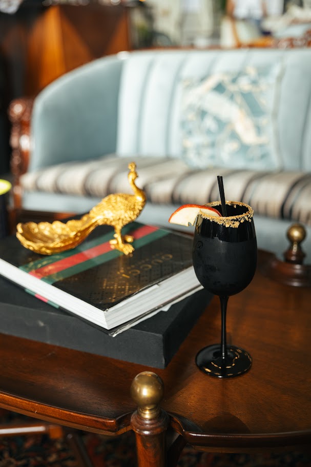 cinnamon apple cocktail in black glass for halloween party