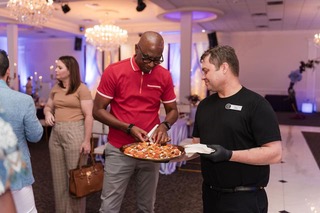 guests taking appetizer from server at event